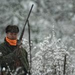 Hunters Hunting in winter wearing blaze orange hunting clothing